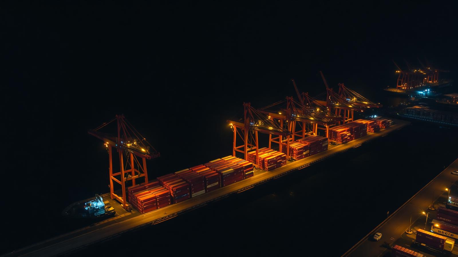 Container terminal at night with cranes loading cargo